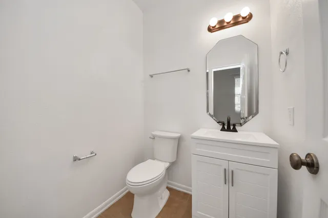 a bathroom with a toilet a sink and mirror