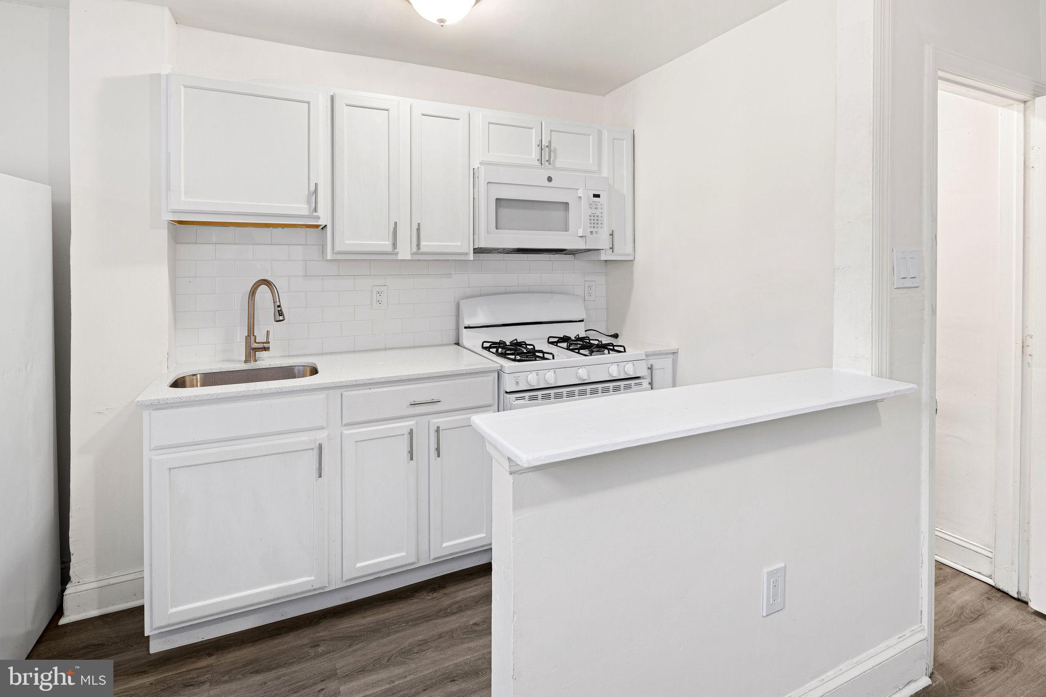 614 Littlecroft Road Upper Darby, PA 19082 - Photo 7 of 13 a kitchen with white cabinets and appliances