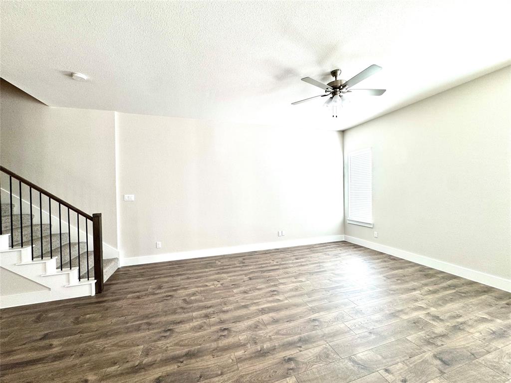 809 Meadowcrest Drive Plano, TX 75075 - Photo 11 of 30 a view of a room with wooden floor and a ceiling fan