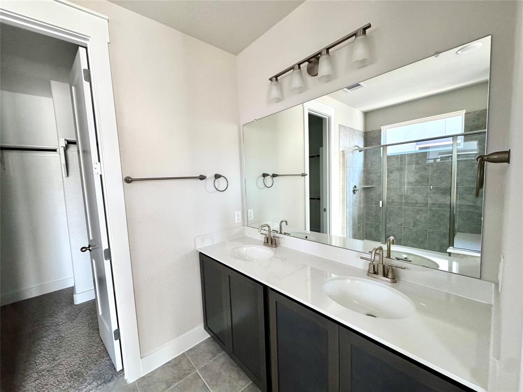 809 Meadowcrest Drive Plano, TX 75075 - Photo 18 of 30 a bathroom with a double vanity sink a mirror and shower