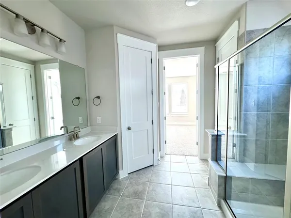 a bathroom with a double vanity sink a toilet and a shower