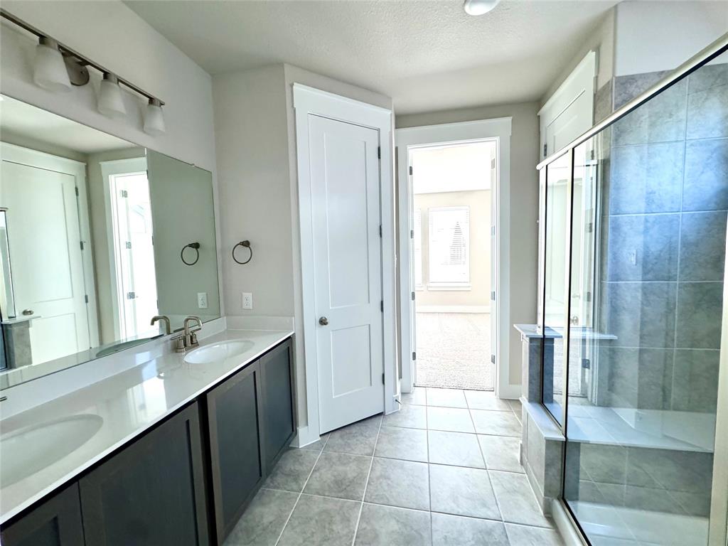 809 Meadowcrest Drive Plano, TX 75075 - Photo 20 of 30 a bathroom with a double vanity sink a toilet and a shower