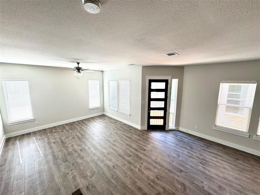 809 Meadowcrest Drive Plano, TX 75075 - Photo 4 of 30 an empty room with wooden floor closet and windows