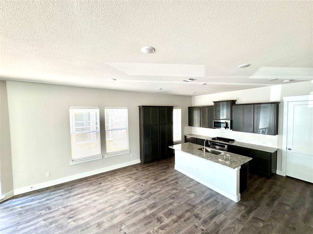 809 Meadowcrest Drive Plano, TX 75075 - Photo 10 of 30 a living room with stainless steel appliances granite countertop a stove and a refrigerator