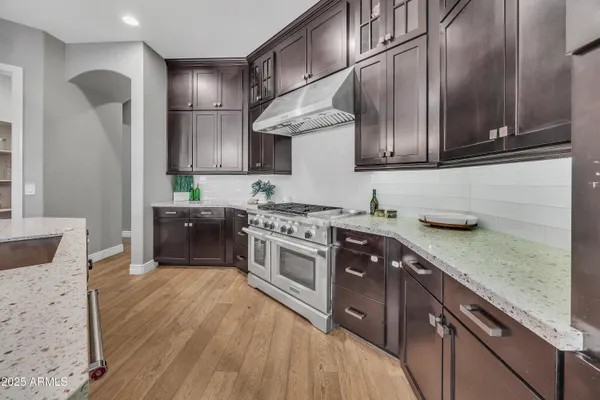 a kitchen with stainless steel appliances granite countertop a sink a stove and a refrigerator