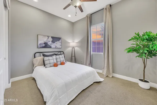 a bedroom with a bed and a potted plant