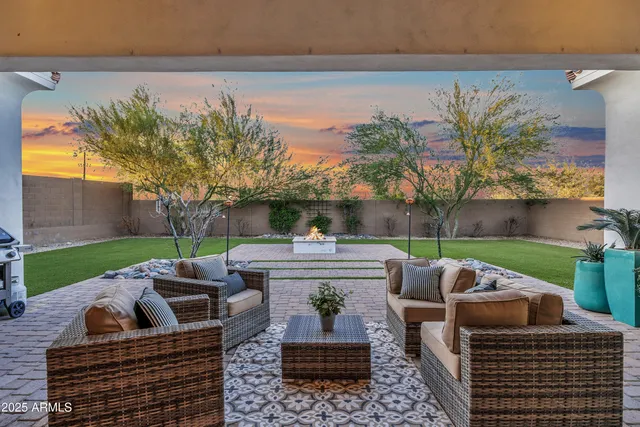 a view of a patio with couches chairs potted plants and a big yard