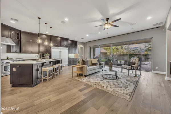 a large white kitchen with lots of counter space a sink appliances and dining table