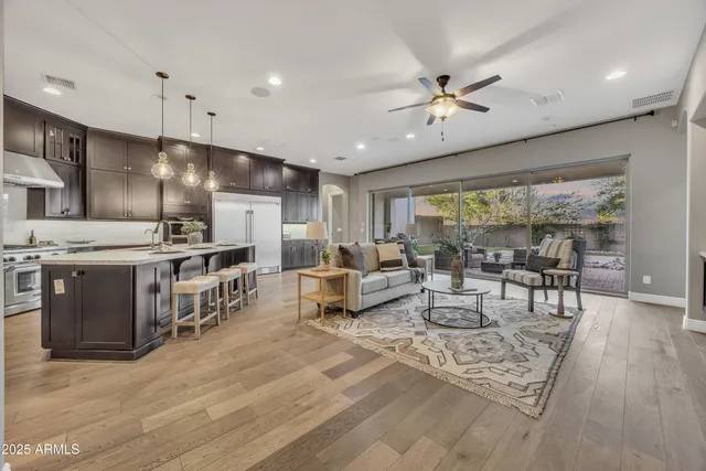 a large white kitchen with lots of counter space a sink appliances and dining table