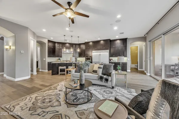 a living room with furniture kitchen view and a chandelier