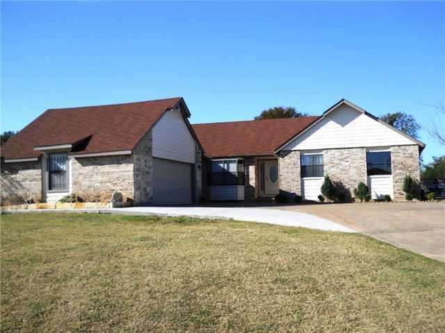 12410 Twin Creek Road Manchaca, TX 78652 - Photo 2 of 32 a front view of a house with a garden and yard