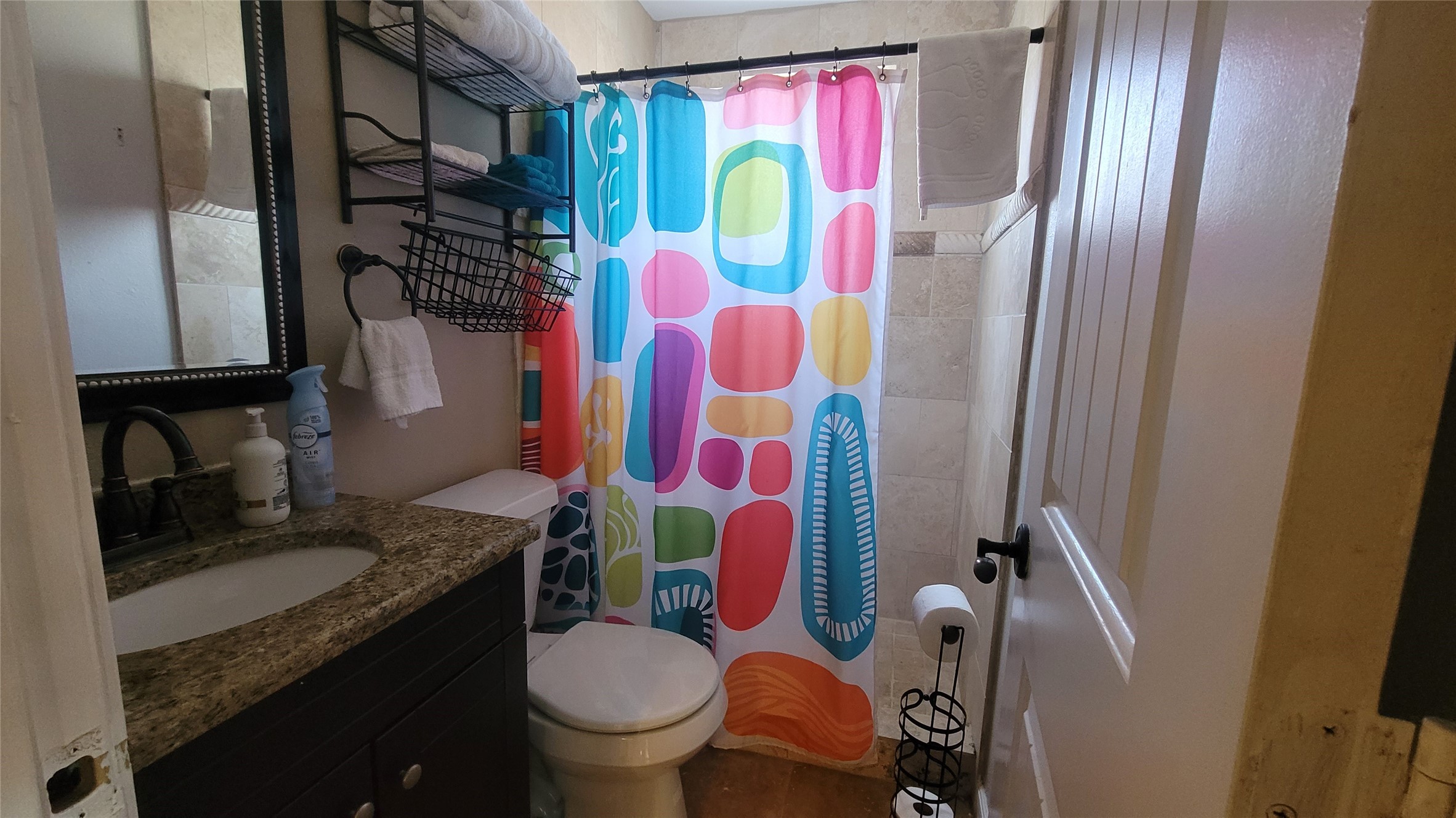 12410 Twin Creek Road Manchaca, TX 78652 - Photo 27 of 32 a bathroom with a granite countertop toilet sink and mirror