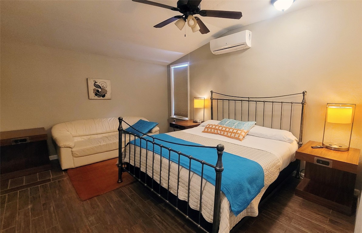 12410 Twin Creek Road Manchaca, TX 78652 - Photo 30 of 32 a bedroom with a bed and a chandelier