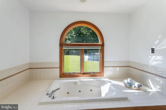 a bath tub sitting in a bathroom next to a window