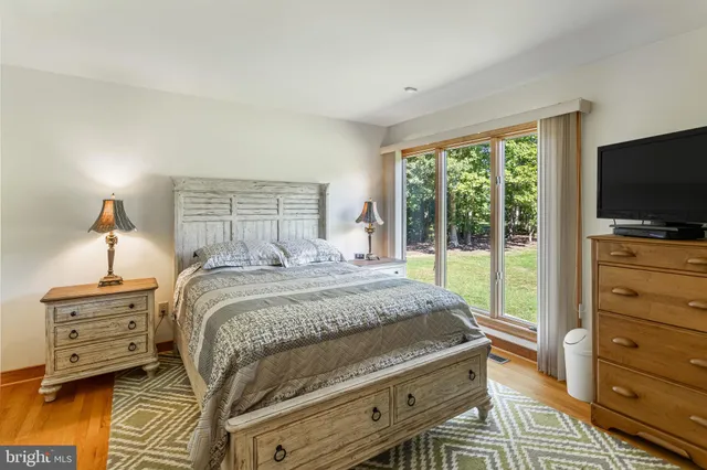 a bedroom with a bed and a tv on the dresser