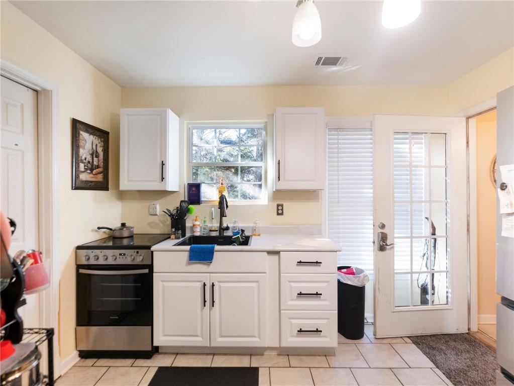 7389 Williams Road Flowery Branch, GA 30542 - Photo 23 of 49 a kitchen with stainless steel appliances a stove sink and cabinets