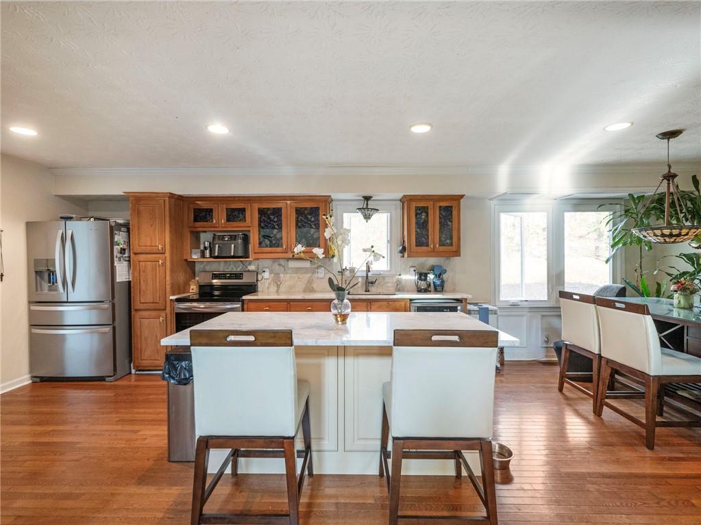 7389 Williams Road Flowery Branch, GA 30542 - Photo 3 of 49 a dining room with stainless steel appliances a dining table chairs and wooden floor