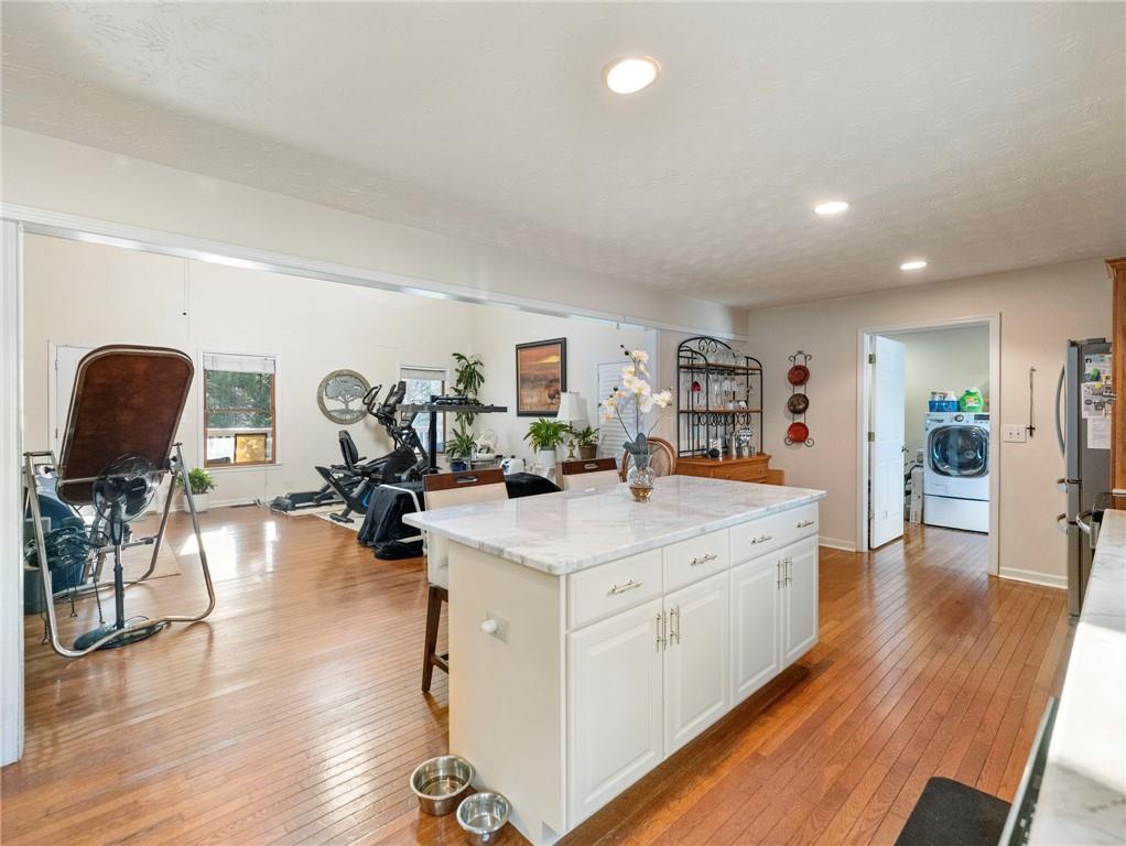 7389 Williams Road Flowery Branch, GA 30542 - Photo 6 of 49 a view of living room kitchen with furniture and wooden floor