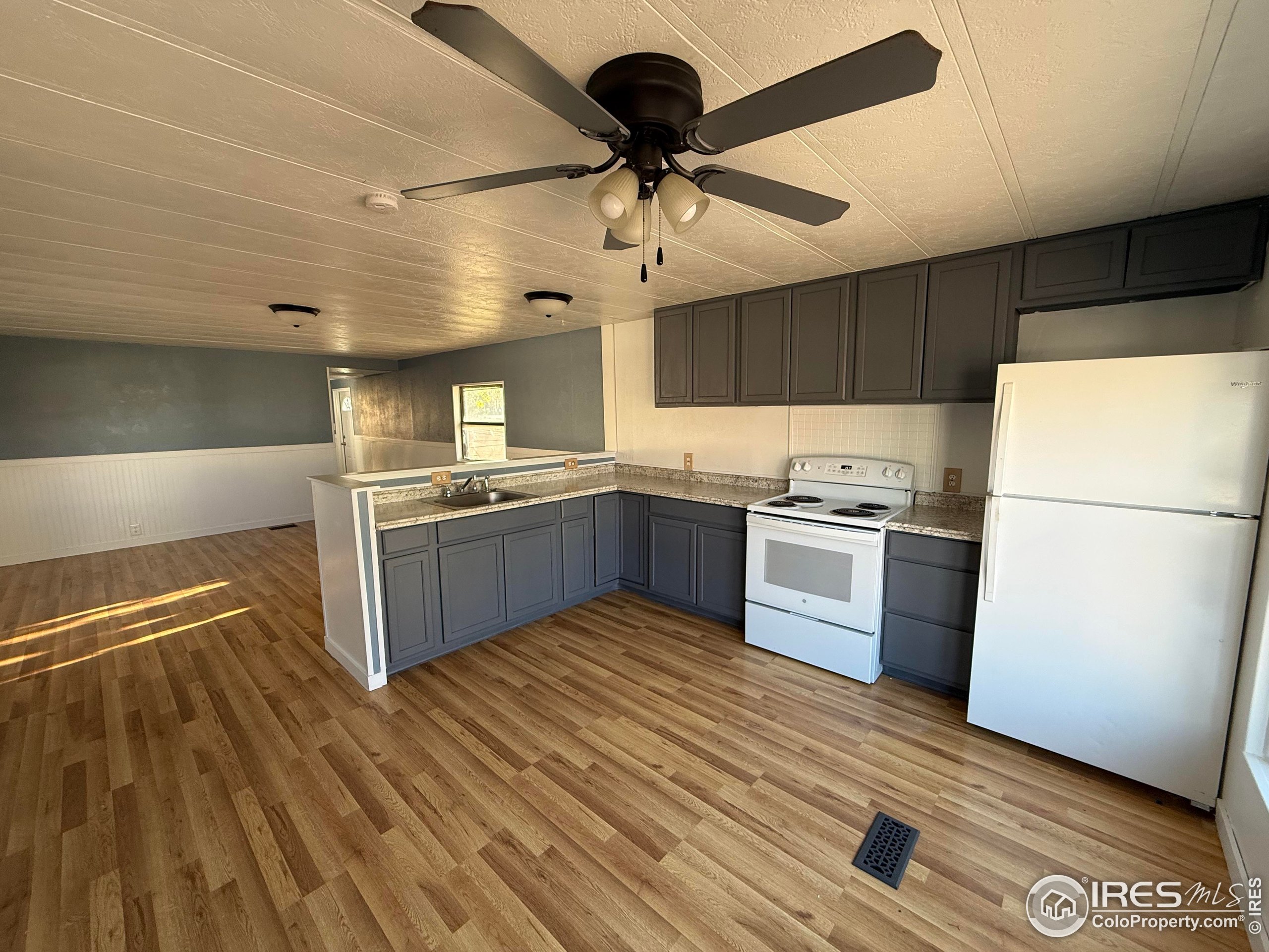 830 1st Street, Unit 23 Pierce, CO 80650 - Photo 3 of 16 a kitchen with granite countertop a refrigerator and a stove top oven