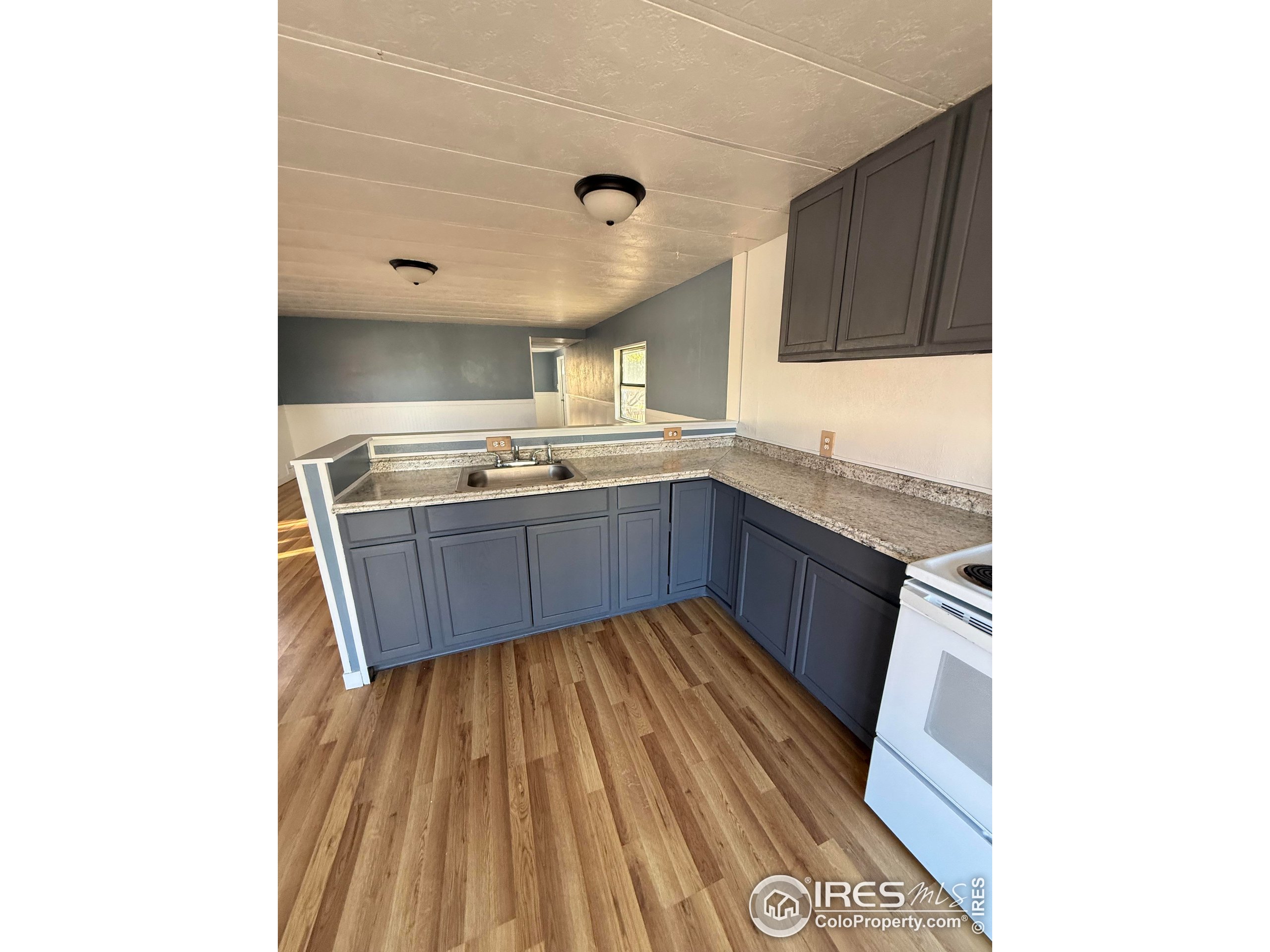 830 1st Street, Unit 23 Pierce, CO 80650 - Photo 7 of 16 a kitchen with stainless steel appliances granite countertop a sink and wooden cabinets
