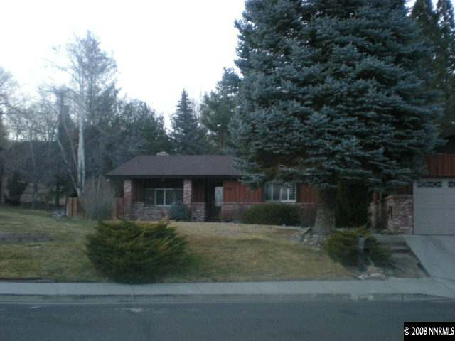a front view of a house with a yard and trees