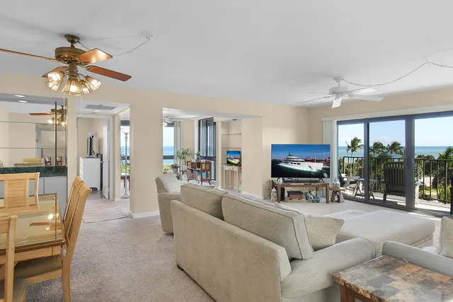 a living room with furniture and floor to ceiling windows