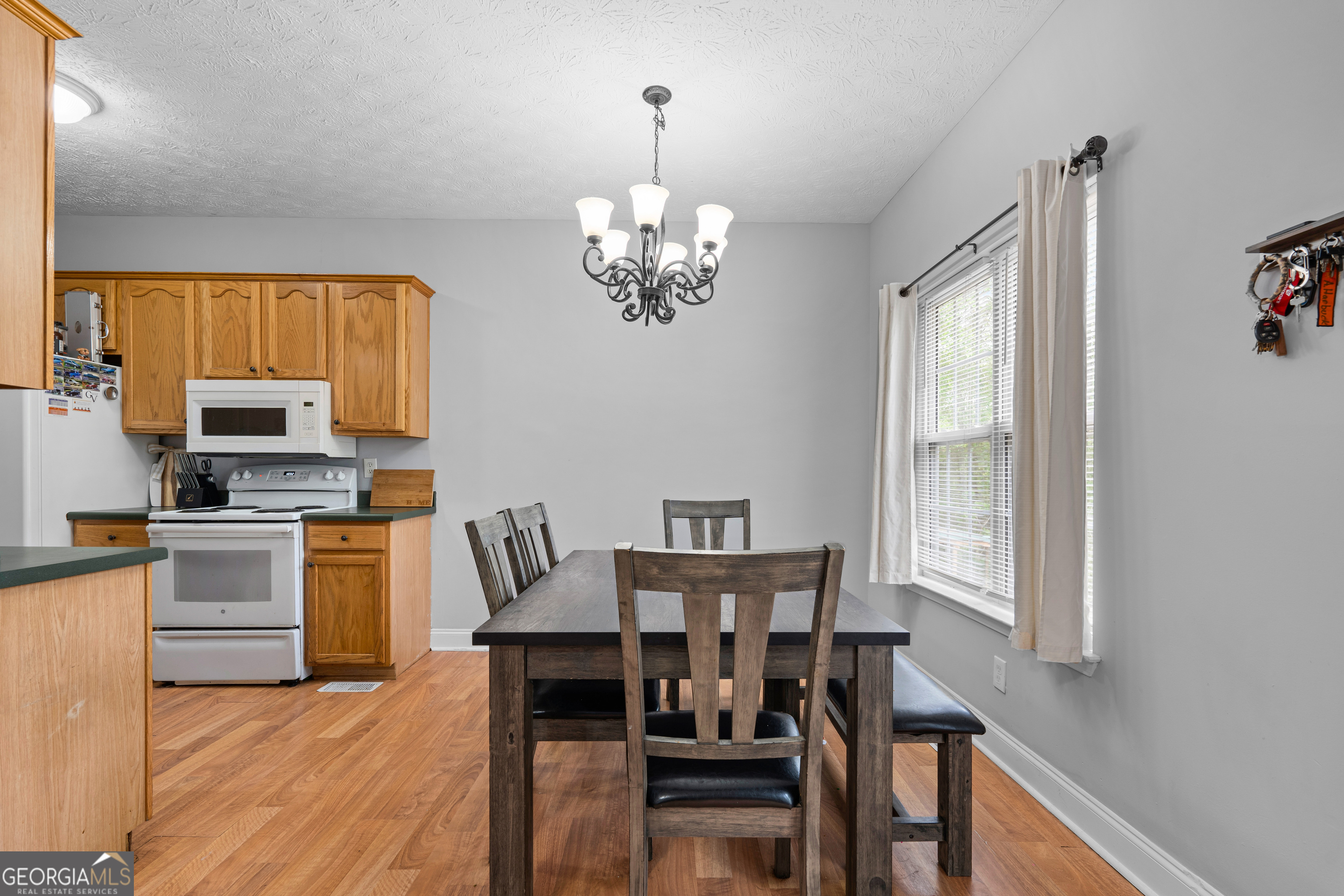 35 South Robin Lane Newnan, GA 30263 - Photo 12 of 50 a view of a dining room with furniture a chandelier and wooden floor