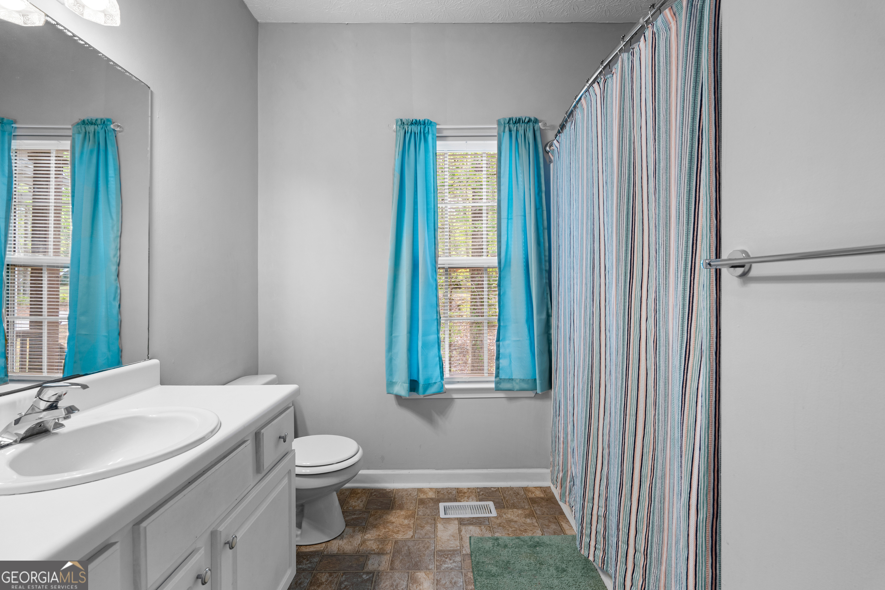 35 South Robin Lane Newnan, GA 30263 - Photo 30 of 50 a bathroom with a granite countertop sink a toilet and mirror