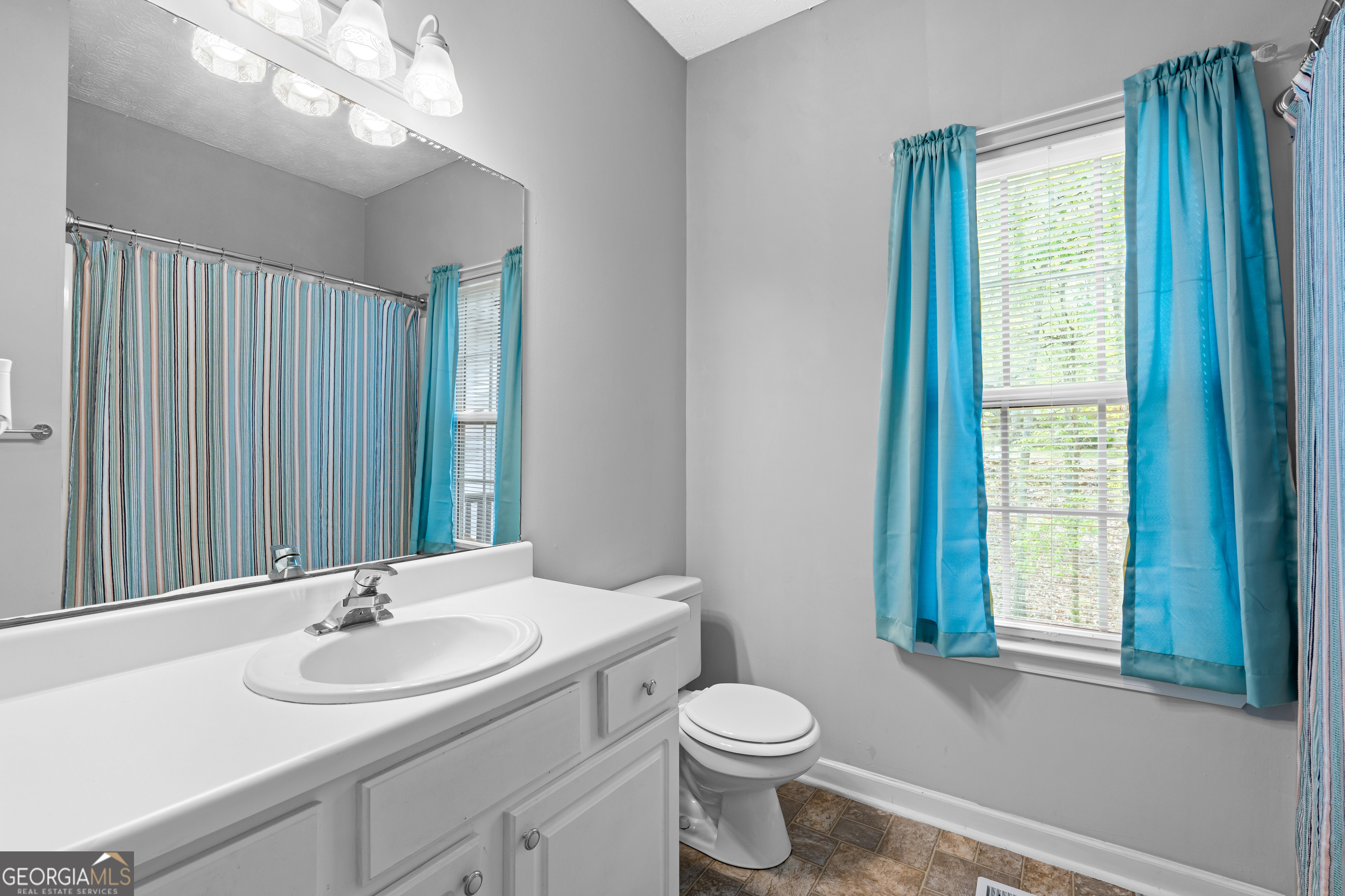 35 South Robin Lane Newnan, GA 30263 - Photo 31 of 50 a bathroom with a sink a toilet and a mirror