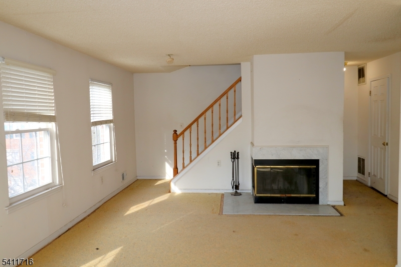 12 Rutgers Drive, Unit 12 Newark, NJ 07103 - Photo 4 of 22 a view of an empty room with fireplace and a window