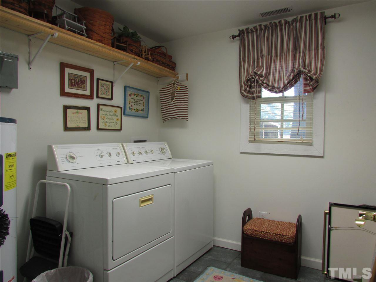 1231 Chambers Loop Road Timberlake, NC 27583 - Photo 12 of 22 Utility room has water heater, shelving, tile floor. A washer and dryer will convey but not the ones in the picture