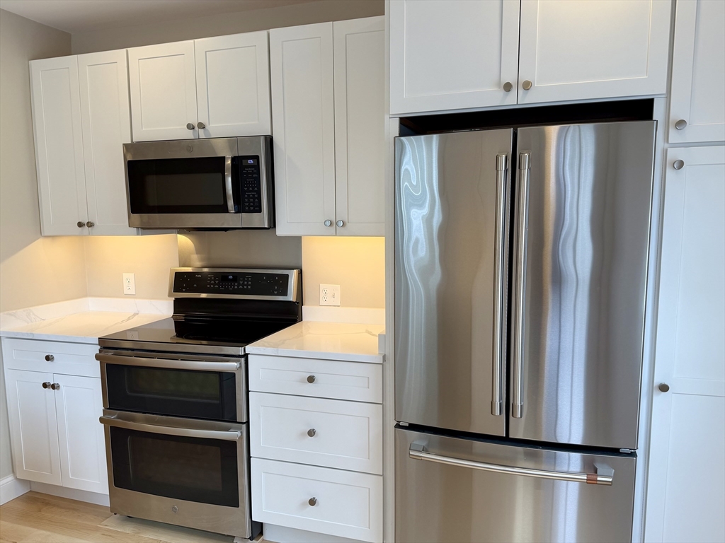 15 River Street, Unit 1 Beverly, MA 01915 - Photo 2 of 17 a kitchen with stainless steel appliances a refrigerator stove and microwave