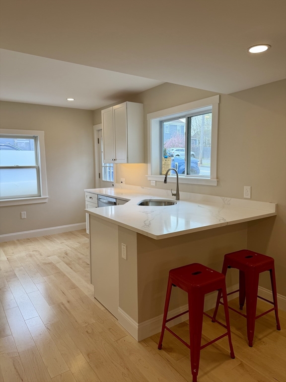 15 River Street, Unit 1 Beverly, MA 01915 - Photo 6 of 17 a kitchen with a table chairs and wooden floor