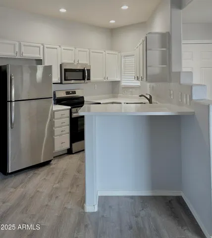 a kitchen with stainless steel appliances a refrigerator sink and microwave