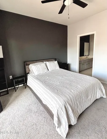 a bedroom with a bed and a ceiling fan