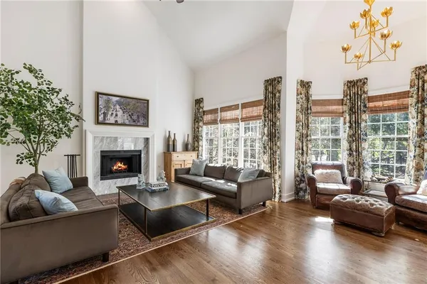 a kitchen with stainless steel appliances kitchen island granite countertop a refrigerator a stove and white cabinets with wooden floor