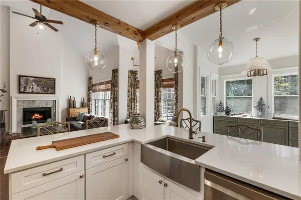 a spacious bedroom with a bed a flat tv screen and a chandelier