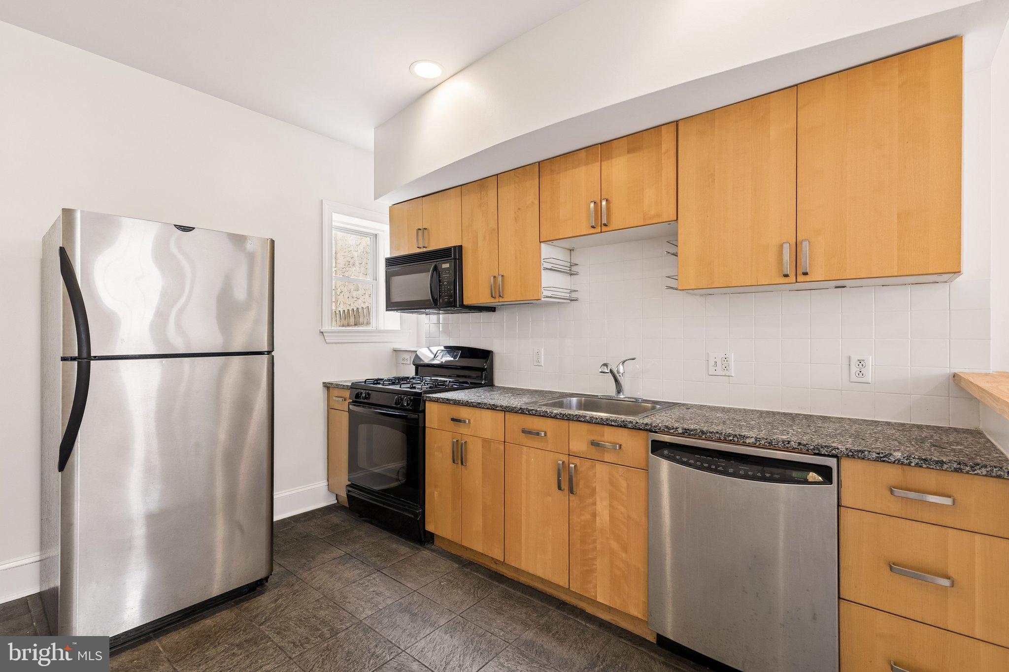 714 South 18th Street Philadelphia, PA 19146 - Photo 10 of 28 a kitchen with stainless steel appliances granite countertop a refrigerator a sink dishwasher a stove top oven a refrigerator and cabinets with wooden floor