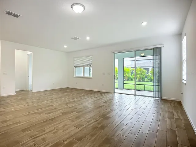 a view of kitchen with kitchen island a sink wooden floor and stainless steel appliances