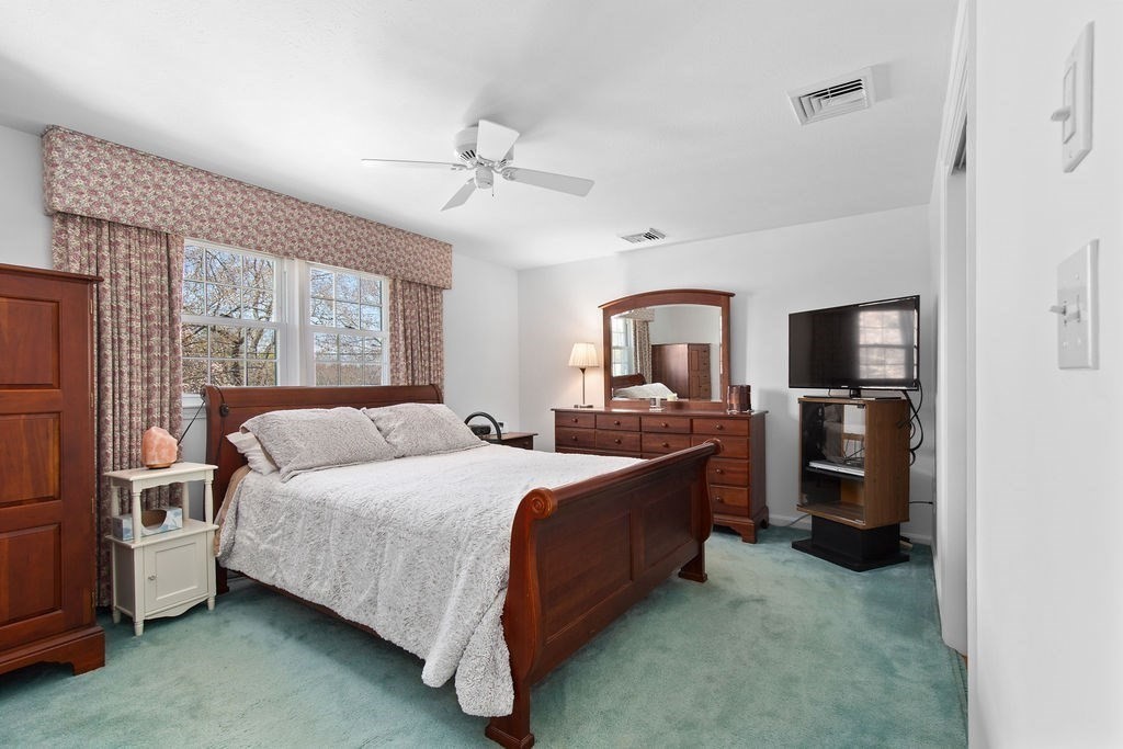 71 Pond Lane Randolph, MA 02368 - Photo 19 of 35 a bedroom with a bed wooden floor and flat screen tv