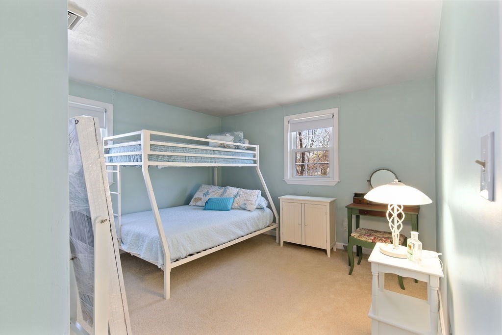 71 Pond Lane Randolph, MA 02368 - Photo 21 of 35 a bedroom with a bed and a table