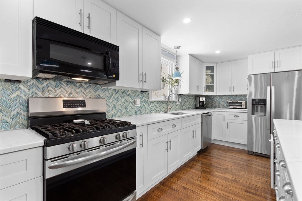 71 Pond Lane Randolph, MA 02368 - Photo 4 of 35 a kitchen with stainless steel appliances granite countertop a stove microwave sink and refrigerator