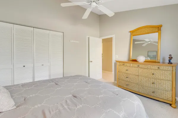 a spacious bedroom with a large bed and a mirror