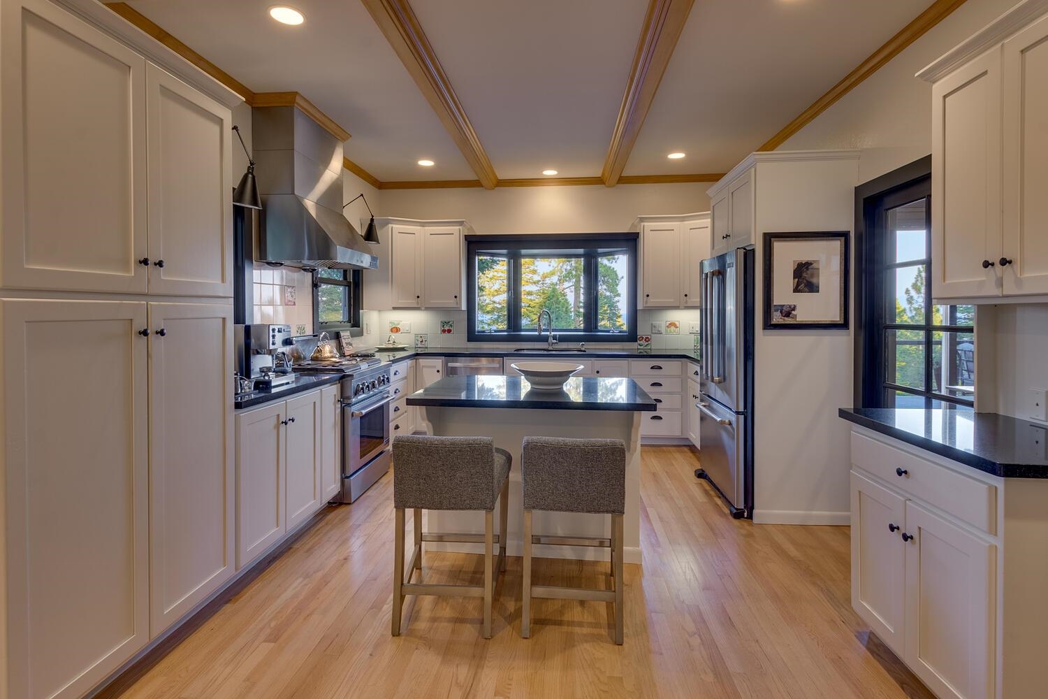 260 Old County Road Carnelian Bay, CA 96140 - Photo 13 of 28 a kitchen with stainless steel appliances kitchen island granite countertop a table chairs cabinets and wooden floor