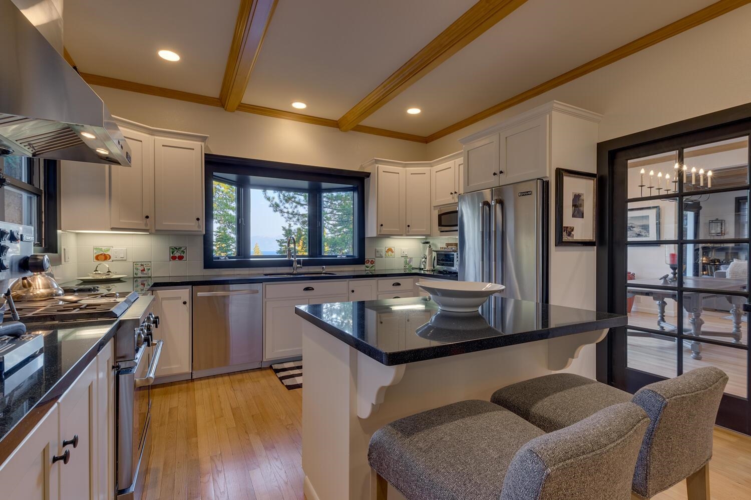 260 Old County Road Carnelian Bay, CA 96140 - Photo 15 of 28 a kitchen with stainless steel appliances granite countertop a refrigerator a sink dishwasher a stove and a dining table with wooden floor