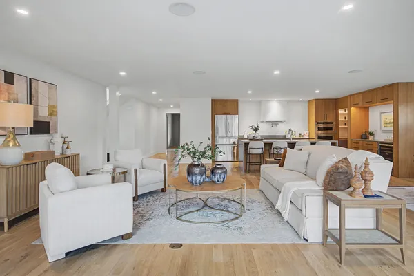 a living room with furniture kitchen view and a large window