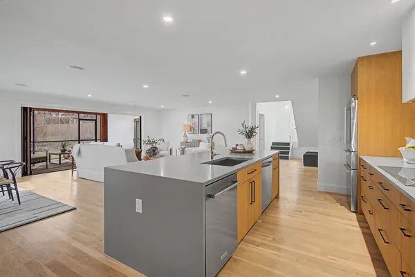 a large kitchen with stainless steel appliances a large counter top a stove and a sink