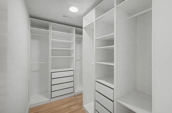 a view of walk in closet with empty racks