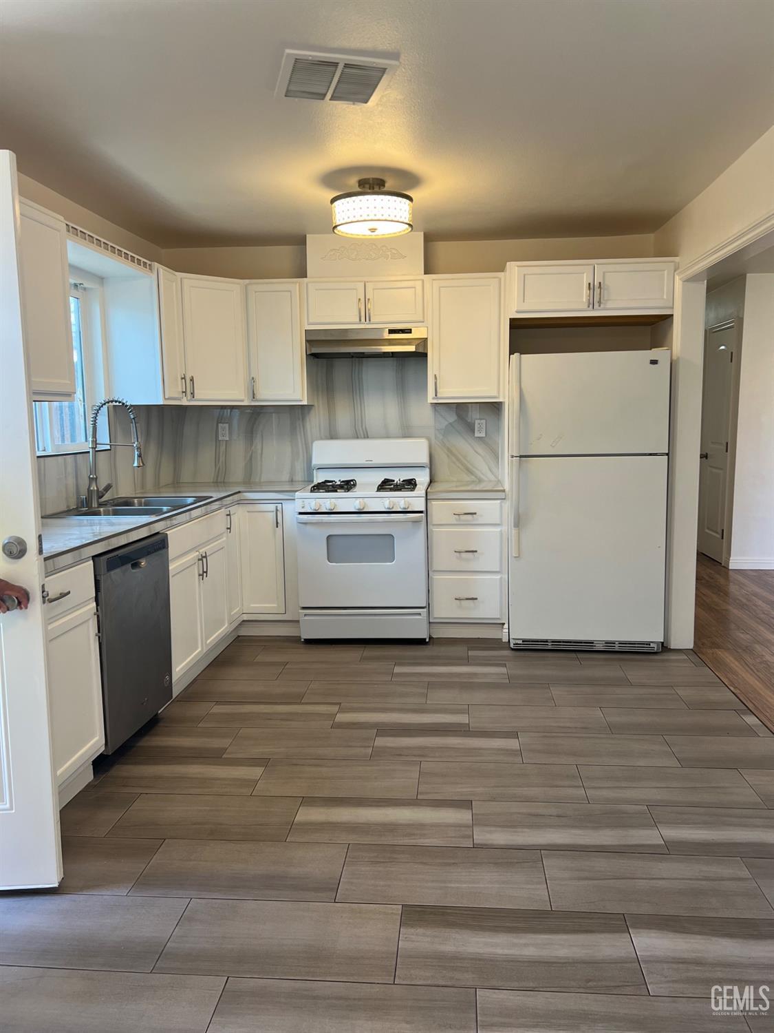 Undisclosed Address Bakersfield, CA 93304 - Photo 4 of 22 a kitchen with a stove top oven cabinets and a refrigerator