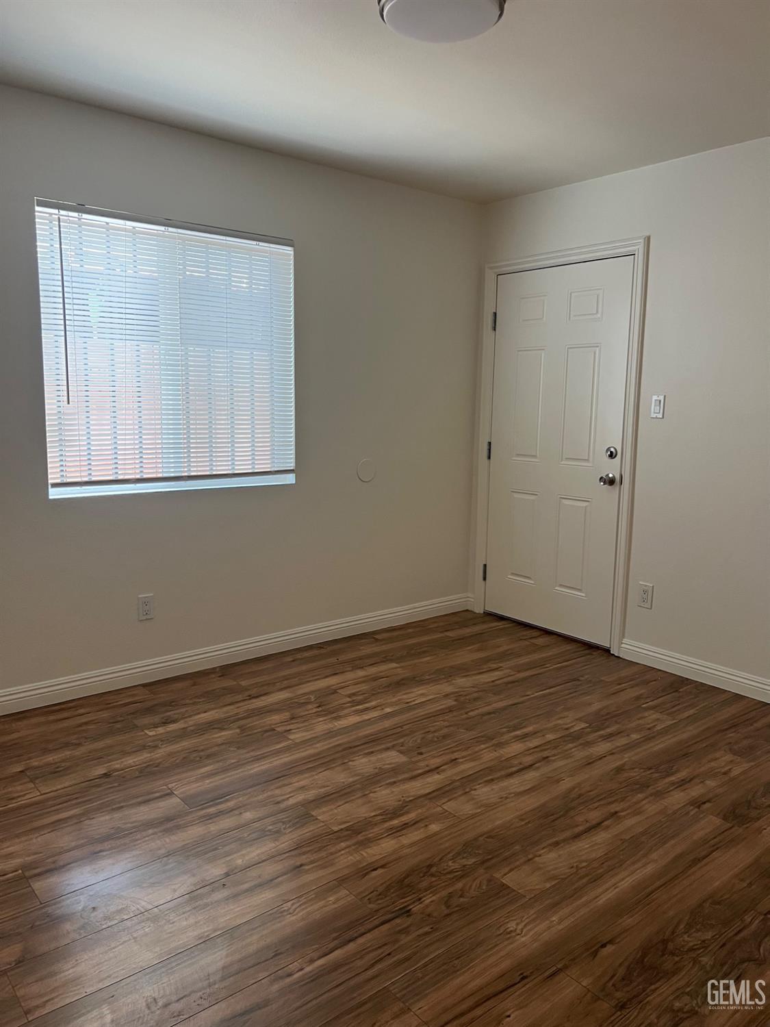Undisclosed Address Bakersfield, CA 93304 - Photo 8 of 22 a view of an empty room with wooden floor and a window